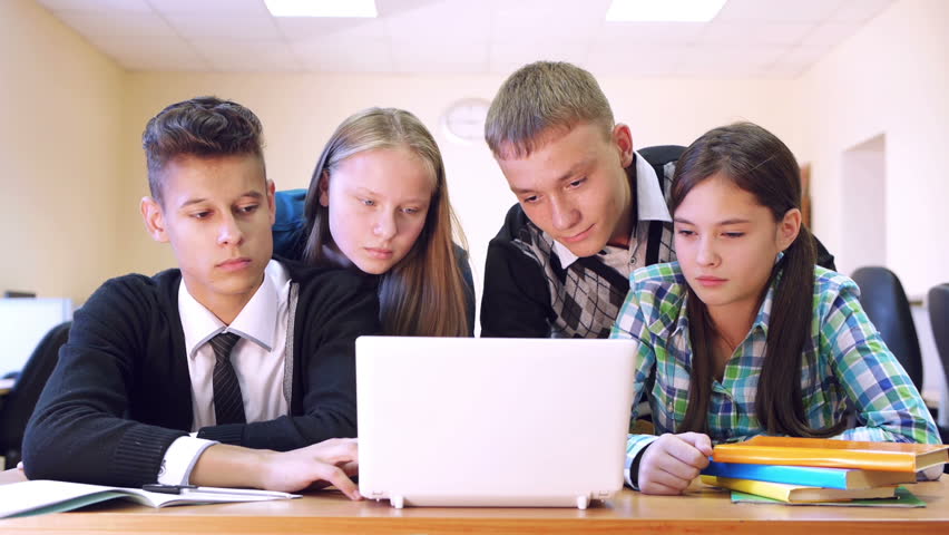 Four young students high school having conversation in the classroom