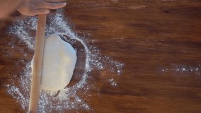Woman rolls the dough, top view slow motion video
