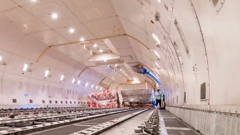 Zoom out time lapse unloading cargo inside cargo plane