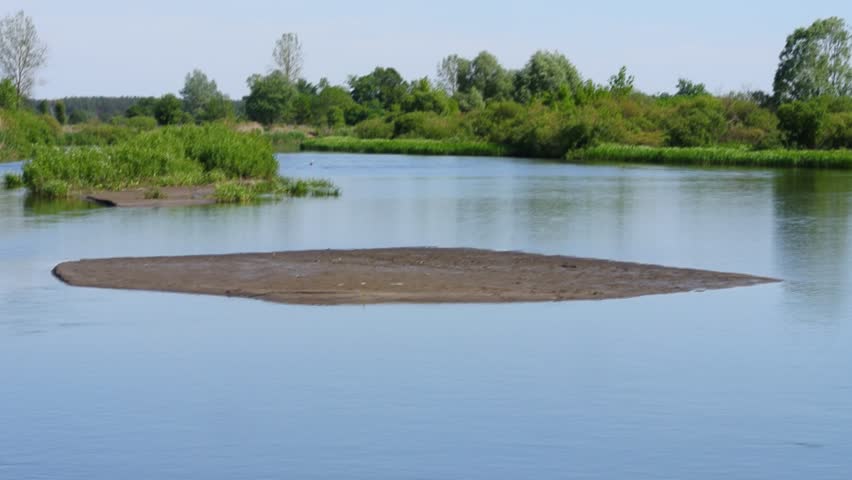 An islet in the middle of a fast river with green water