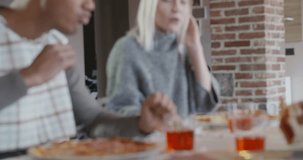 multiethnic group of friends people enjoy having lunch or dinner meal together eating pizza indoor in modern industrial house. 4k handheld slow motion close up video shot