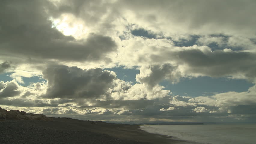 Time lapse of clouds moving over land and sea