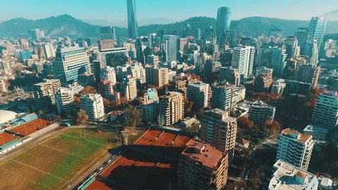 Aerial footage of Santiago de Chile, revealing the financial district, some tennis court and The Andes Mountains from the air. 