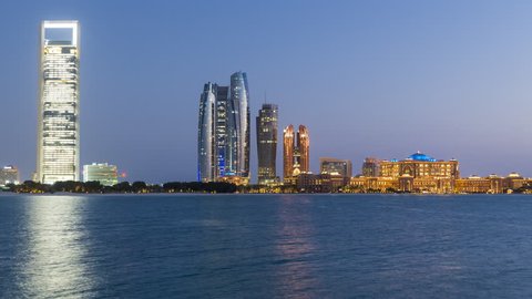  Abu Dhabi. Etihad Towers and Emirates Palace hotel time lapse viewed from the Breakwater, Abu Dhabi, United Arab Emirates, Middle East