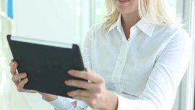 Lovely business lady considering new opportunities for development using her tablet computer