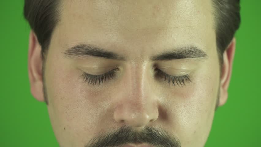 Close up of young man's eyes opening slow motion. Greenbox clean background.
