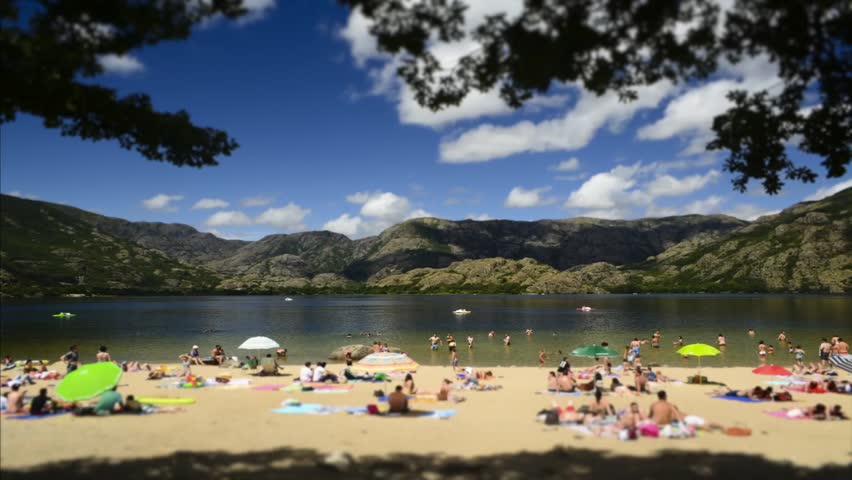 Time lapse of people in a lake beach. People blurred. Tilt shift effect