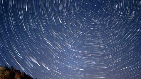 Night sky stars becoming time lapse star trails circling around Polaris the North Star in night sky, shooting star, flight path and northern light flashing by. 4k