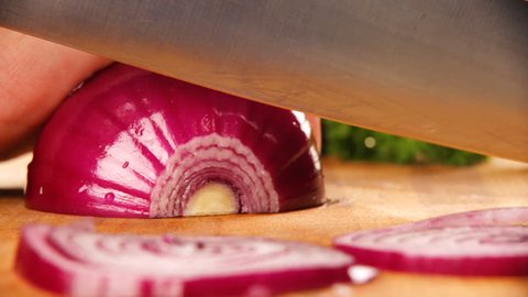 chef slices the onion. Knife, cutting Board, onion. Quick cutting of vegetables. Half rings of onions. bow for frying. The hands of the cook. Cut vegetables for salad. Healthy food. Close-up. Macro
