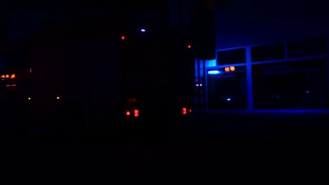 Fire engine (truck) and ambulance car at night. Emergency lights, firemen and medical staff. Fire engine intervention. Firefighters and firebrigade.