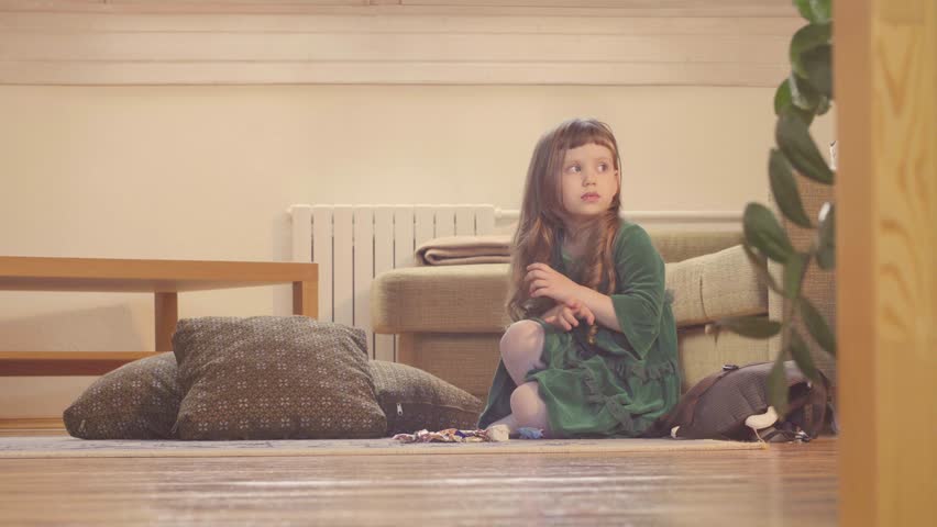 A girl in nice green dress sitting on the floor