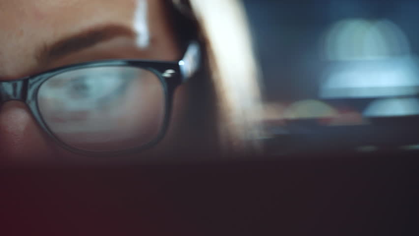 Attractive young businesswoman working at night via computer at office with, closeup of hipster student girl browsing the internet, looking at monitor of modern computer, focus on the glasses Royalty-Free Stock Footage #27590086