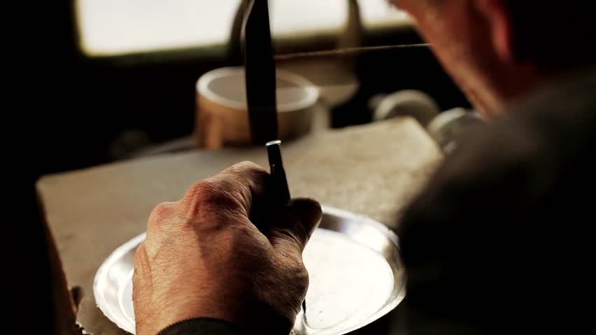 Traditional tinsmith work. Copper smith makes embossing artifacts from copper. Designing utensils, the age old art of crafting wares. Copper engraving. Souvenirs. Shooting close-up Copper smith work.