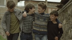 Childhood Memories.  View of a group of teen friends enjoying a walk, hugging each other. Vintage times. Childhood Memories. Shot on RED EPIC DRAGON Cinema Camera in slow motion.