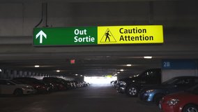 Green sign showing the way out with pedestrian warning. Parking garage. Handheld stabilized shot.
 - Powered by Shutterstock - Get 15% off with code: PIKWIZARD15