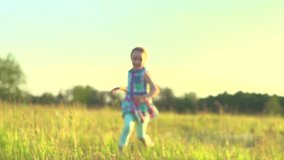 Happy child running on summer field and laughing. Healthy little girl enjoying nature on spring meadow, raising hands, smile. Outdoors. Sunset. Slow motion. 4K UHD video 3840X2160