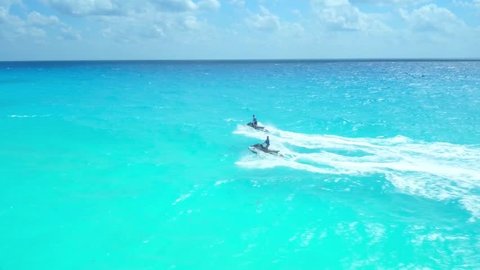 Man and Women on Jetskis in Blue Ocean