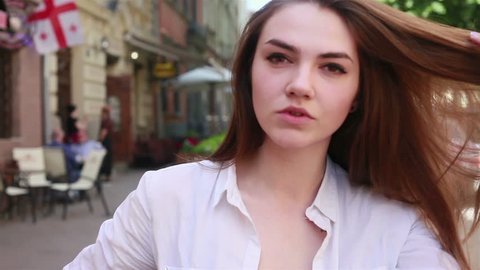 people, emotions, natural, beauty and lifestyle concept -Young beautiful woman close up portrait smiling in the street. Slow motion . video 4k, 3840, 2160, Ultra HD
