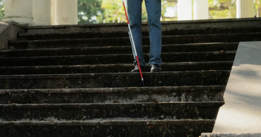 Hispanic blind man, latino people with disability, handicapped person and everyday life. Visually impaired man with walking stick, descending steps in city park