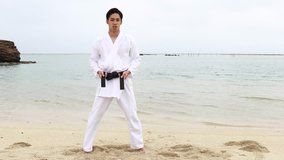 Young man practicing karate at the beach
