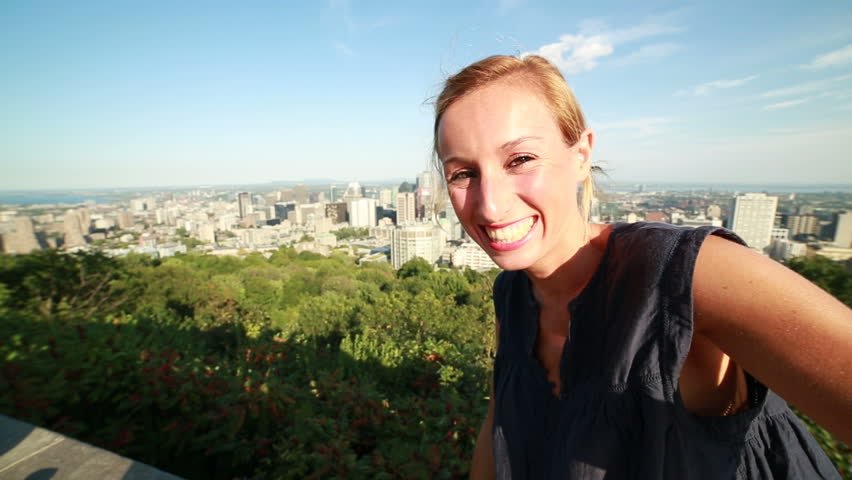 Young woman taking selfie in Montreal
Young cheerful woman in Montreal-Canada taking a selfie using her mobile phone. Point of view taken from the Mont Royal park.