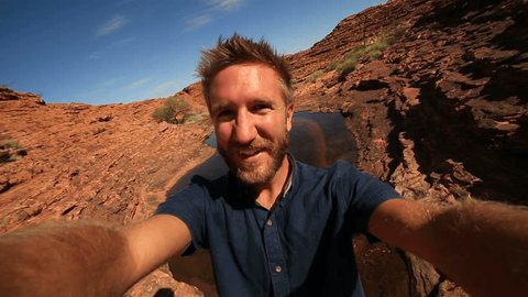 Travel man hiking takes selfie portrait
Young man hiking in Australia take a selfie portrait with the landscape of kings canyon in outback, red centre of Australia.