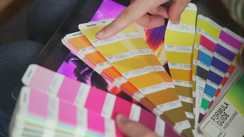Color model Pantone, PMS (Pantone Matching System). Female hands hold a fan pantone - a choice of colors for the future product. Color Palette Guide. Creative people workplace