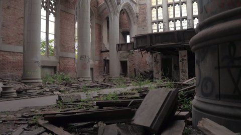 CLOSE UP: Exploring stunning crumbling nave in abandoned City Methodist Church, USA. Old religious building collapsing. Ruined pillars, graffiti on the walls, shuttered windows in decaying cathedral