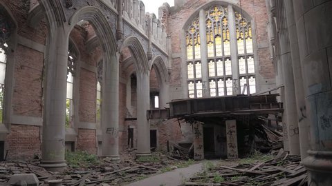 CLOSE UP: Exploring stunning crumbling nave in abandoned City Methodist Church, USA. Old religious building collapsing. Ruined pillars, graffiti on the walls, shuttered windows in decaying cathedral