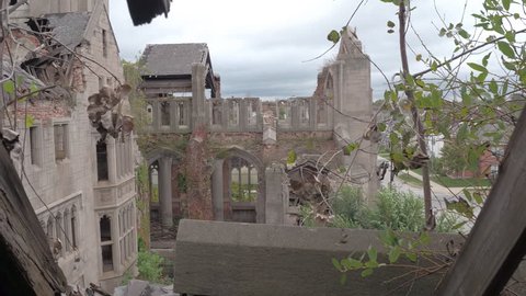 FPV, CLOSE UP: Standing on the roof looking at the crumbling sanctuary in abandoned City Methodist Church, Gary Indiana. Stunning burnt fortress falling apart. Abandoned cathedral disintegrating