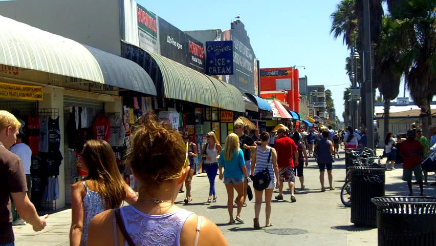 VENICE BEACH, CA - August 2, 2012:  A crowd of people walk past souvenir shops