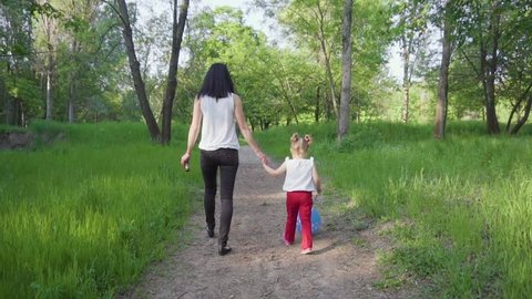 Mom and daughter are walking in the park