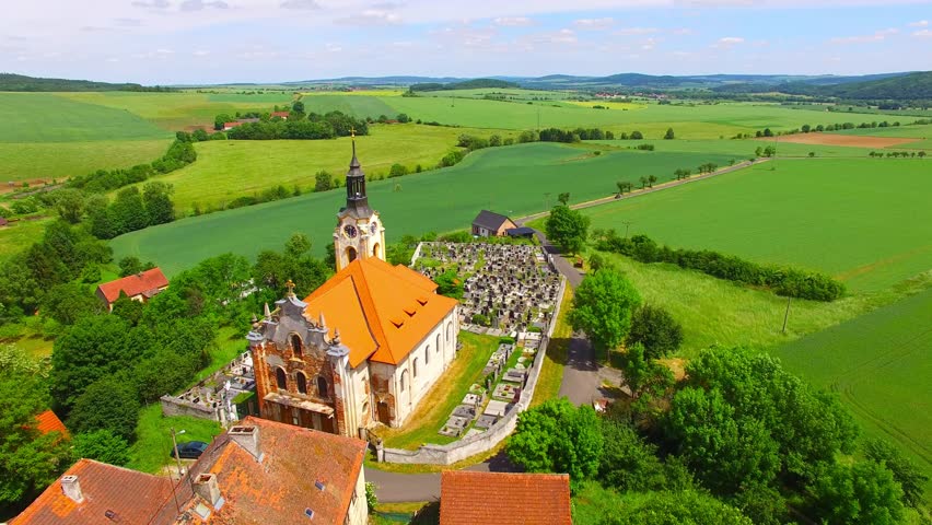 Church of St John the Baptist (1358) with graveyard in small village Vreskovice. Architecture from above. Religious monument in Czech Republic, Central Europe. 