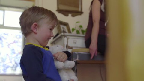 Little boy sees camera and then tries to show it his white toy cat