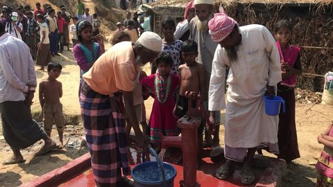 TEKNAF, BANGLADESH - APRIL 1, 2017 : Some Rohingya people pumping water out of the well pipe in refugee camps Kutupalong Rohingya near Cox's Bazar, Bangladesh.
