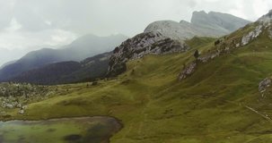Aerial drone flight establisher over green cloudy mountains peaks.Summer adventure journey in mountain nature outdoors. Travel exploring Alps, Dolomites, Italy. 4k video forward