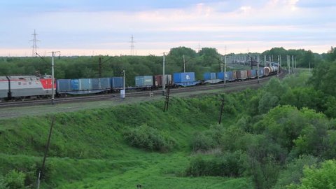 Freight train passing on a railroad track in the countryside
