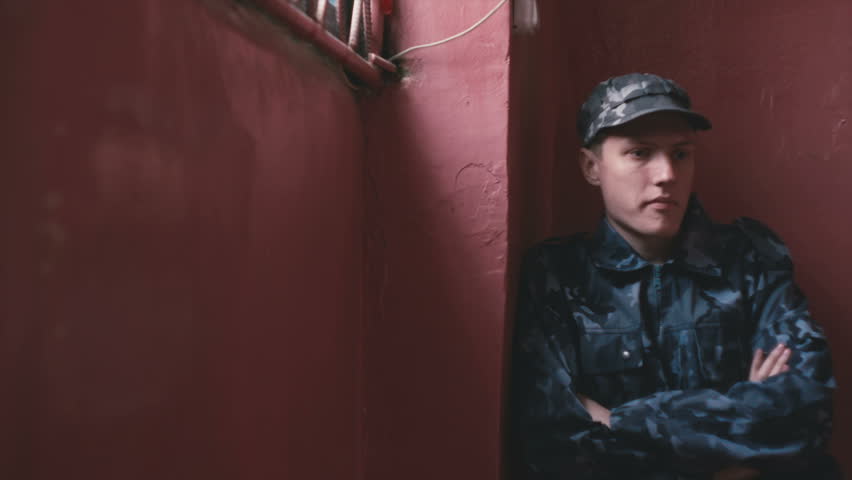 Guard sits by the red wall
