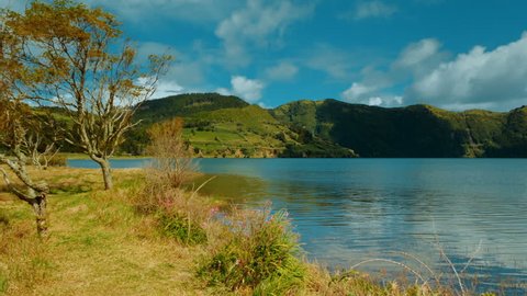 Quaint rural shot of the Blue Lake in Lagoa das Sete Cidades, Sao Miguel Island, The Azores, Portugal on a sunny day. The Azores are one of the hidden gem destinations in Europe.