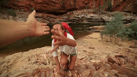 Hiker pulls out his hand to get assistance from teammate
Caucasian female climbing the red rocks in the Australia's outback, pulls out her hand to get assistance from teammate. 