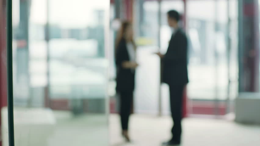 asian business people standing and talking in elevator hall. 