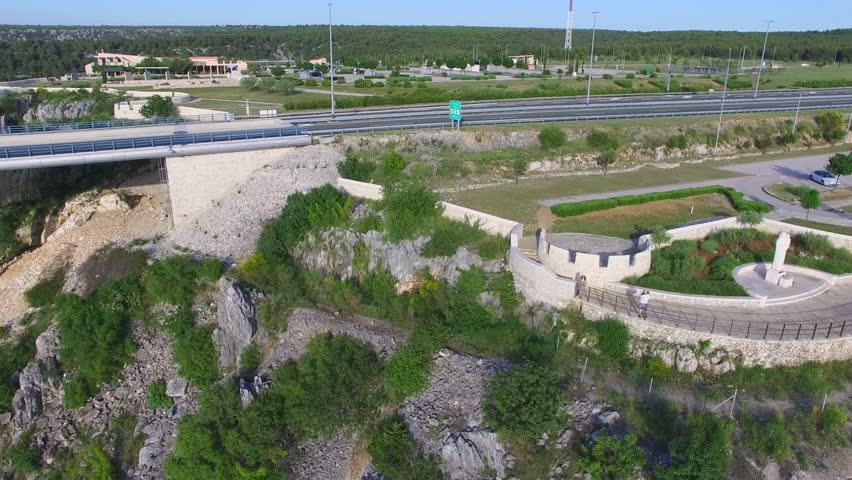 Krka river rest area with parking near highway and autostrada bridge at spring sunny day in Croatia. Aerial view