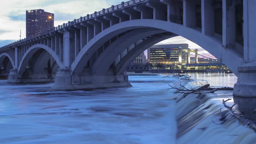 A Medium Shot of Minneapolis Bridges Crossing the Mighty Mississippi River at the St Anthony Power Park Falls at Twilight