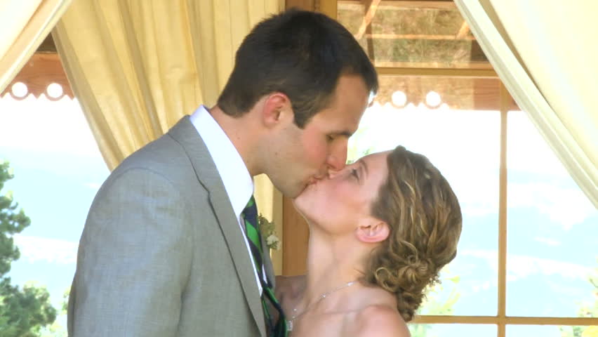 Model released bride and groom kissing and laughing on their wedding day.