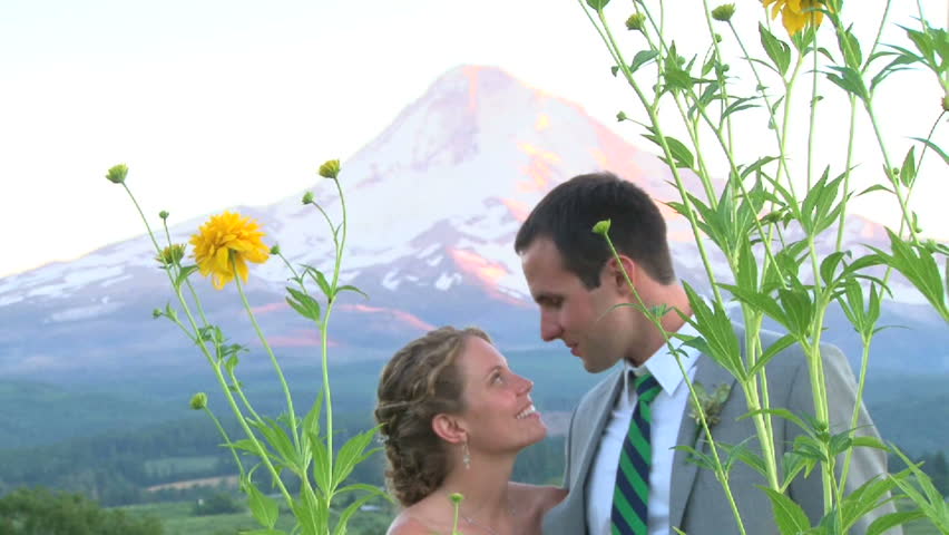 Model released bride and groom kissing on their wedding day by mountain