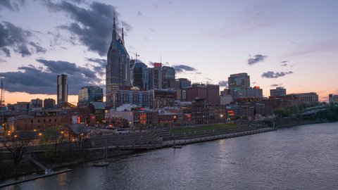 a sunset timelapse of the city of nashville from a bridge across the cumberland river in tennessee