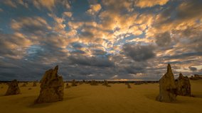 4k time lapse taken at sunset as clouds move in fast motion over The Pinnacles desert in Western Australia. A wide angle view showing storm clouds passing over a desert landscape.
