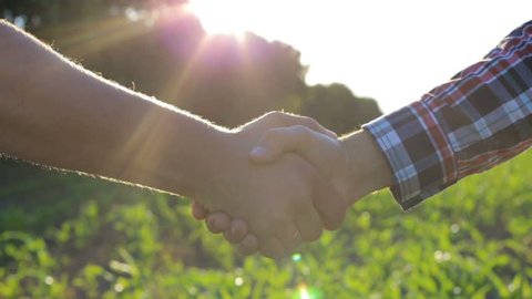 Handshake of two farmers on the field