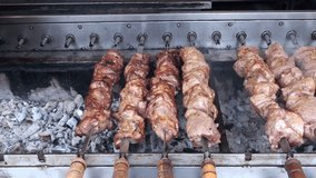 Pieces of juicy meat on skewers roasted on the grill. Full HD 1920x1080 Video Clip