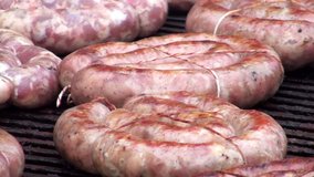 Rings of sausages bandaged rope roasted on a grill. Full HD 1920x1080 Video Clip